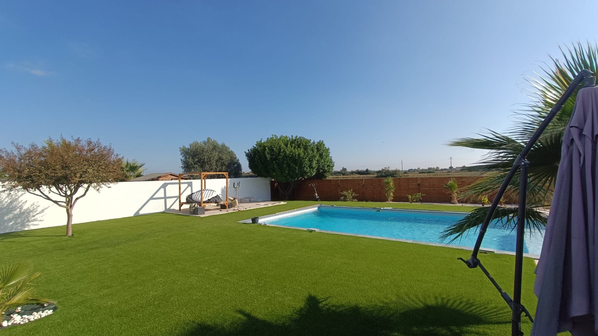 Jardin avec piscine, pelouse en gazon synthétique jusqu'au bord du bassin